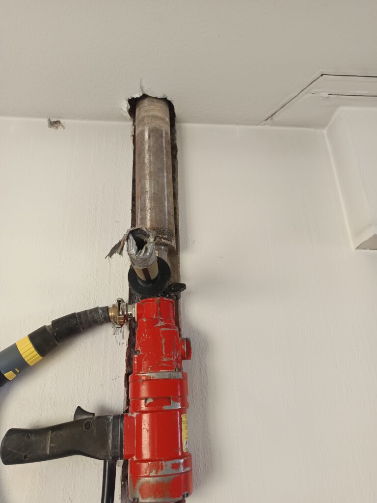Kernbohrung nahe der Decke. Die Bohranlage arbeitet in hoher Position in einem bereits ausgebauten Innenraum.