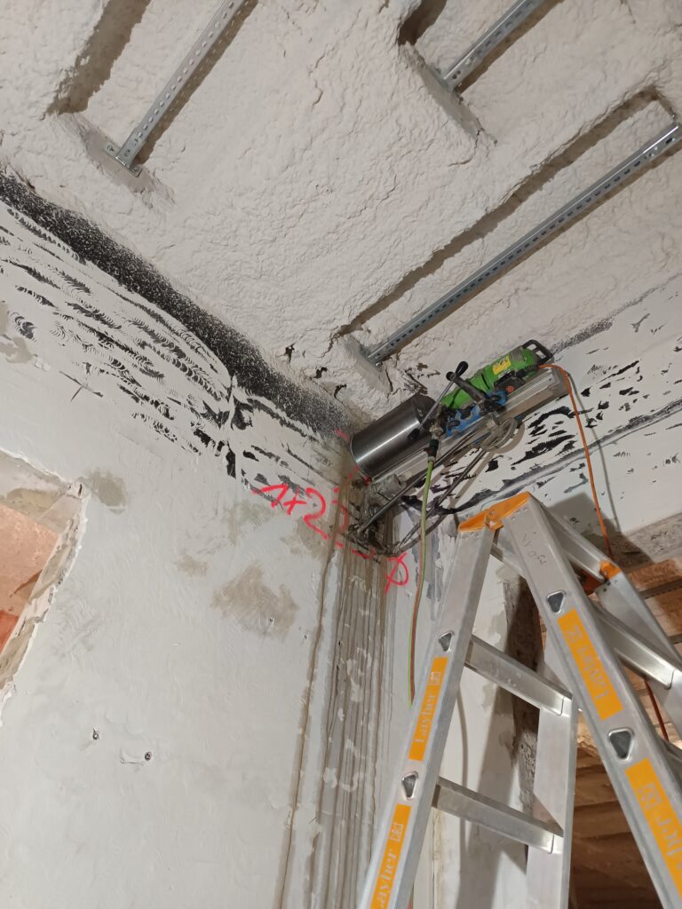 Bohrständer im Deckenbereich. Die montierte Bohranlage arbeitet in hoher Position nahe der Decke.