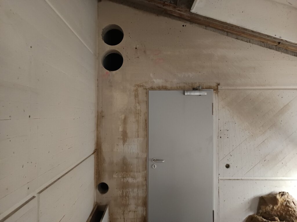 Zwei fertige Kernbohrungen Ø300 und eine fertige Kernbohrung Ø150 in einer Betonwand