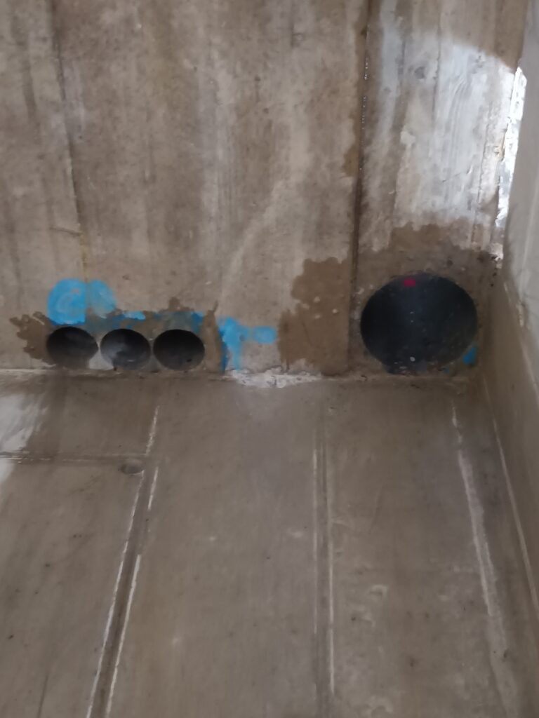 Mehrere runde Leitungsöffnungen. Eine Reihe runder Öffnungen ist in einer Wand des Innenausbaus sichtbar.