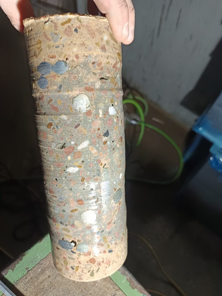 Entnommener Kern mit Materialstruktur. Der herausgelöste zylindrische Kern ist aus kurzer Distanz dokumentiert.