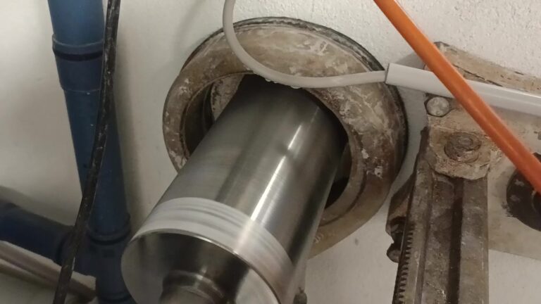 Kernbohrung in engem Arbeitsbereich. Die Bohranlage arbeitet in einem kleinen Installationsraum an einer Wandöffnung.